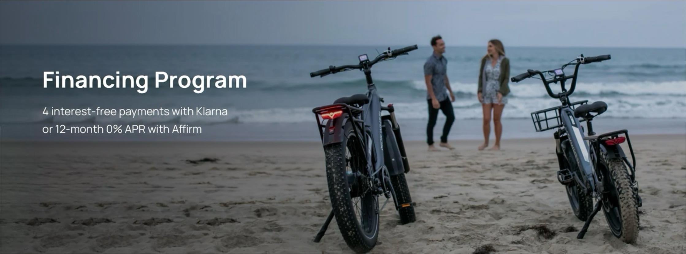 E-bikes parked on the beach with people talking in the background
